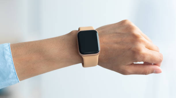 Female hand with smart watch with black blank screen Close up cropped view of female hand with smart watch with black blank screen, selective focus, blurred background. Smartwatch - modern digital gadget with empty display, copy space arm span stock pictures, royalty-free photos & images