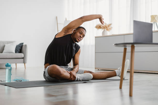 istock African Man Doing Sitting Side-Bend Stretch At Laptop At Home 1322887112