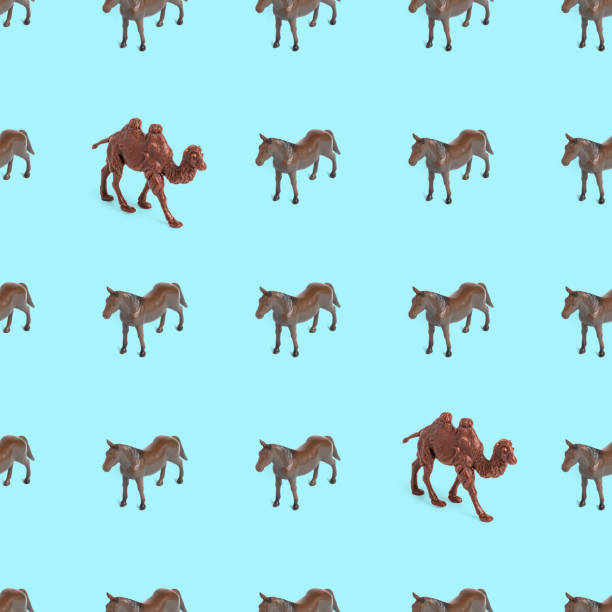 istock Seamless pattern photo of a toy horse and camel on a blue background. 1322887174
