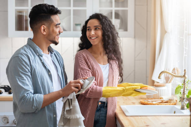 istock Happy Young Arab Spouses Washing Dishes In Kitchen Together 1322887199