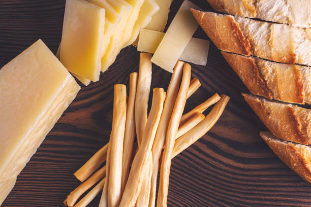 hard cheese and fibrous cheese with slices of bread on a wooden board
