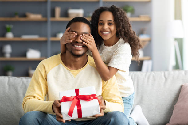 istock Cute curly girl making surprise for her daddy 1322887262