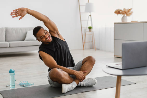 istock African American Guy Doing Stretching Exercise At Laptop At Home 1322888089