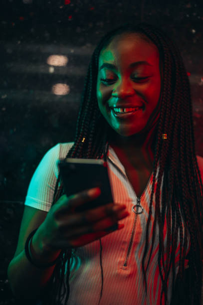istock Cheerful african american woman using smartphone while in a subway 1322889740