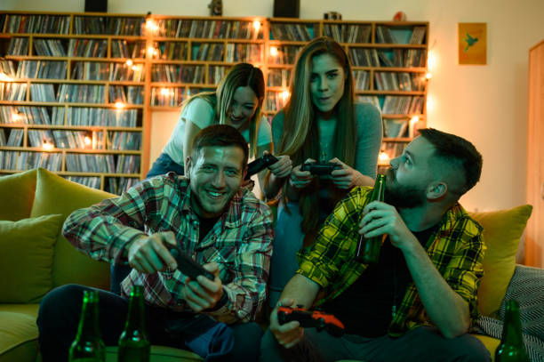 grupa przyjaciół grających w gry wideo podczas relaksu w domu - friendship video game young adult party zdjęcia i obrazy z banku zdjęć