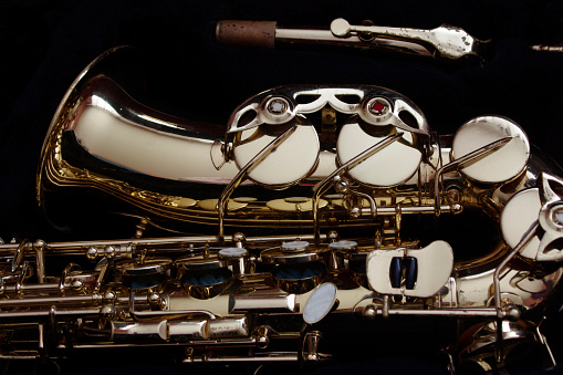 moody closeup of gold saxophone on black