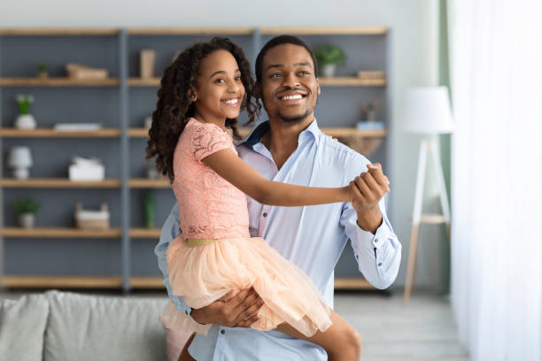 istock Young black dad teaching his beautiful daughter waltz dancing 1322891170
