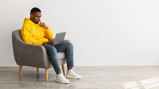 istock African American Man Using Laptop Thinking Working Online, Gray Background 1322892691