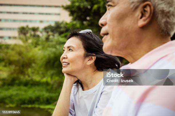 Senior Couple Relaxing In The Park Stock Photo - Download Image Now - Introspection, Couple - Relationship, Friendship