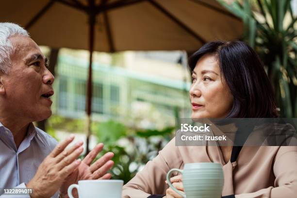 Senior Couple Talking In Outdoor Cafe Stock Photo - Download Image Now - Sadness, Senior Couple, 60-69 Years