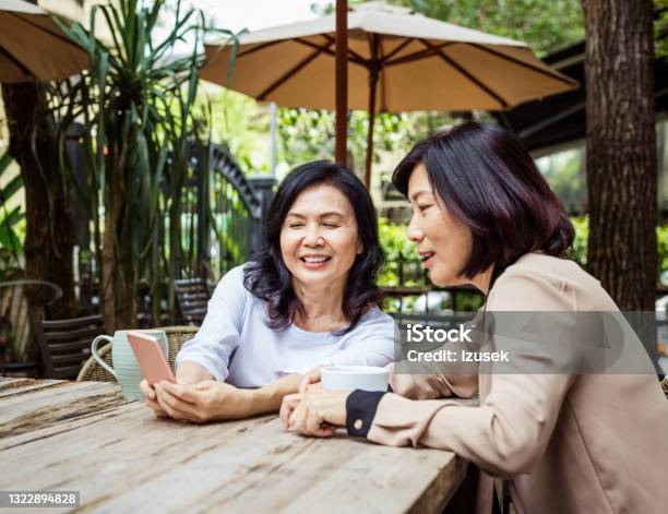 Senior Friends Enjoying Coffee In Outdoor Cafe Stock Photo - Download Image Now - Friendship, Showing, 60-69 Years