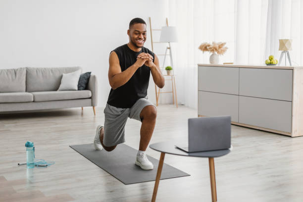 istock African Man Doing Forward Lunge Exercise Watching Online Workout Indoor 1322895724