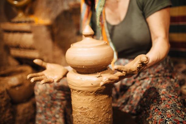 istock woman potter working on lathe close-up hands 1322895780