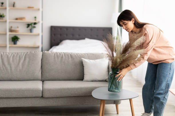 istock Woman putting vase with dried flower grass on table 1322895801