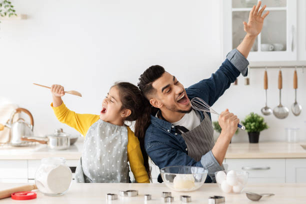 istock Cheerful arab father and little daughter having fun while baking in kitchen 1322895879