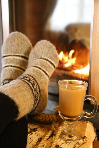 istock Feet in wool socks warming at the fireplace 1322895901