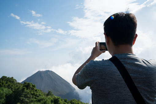 A traveler taking photo of a volcano in El Salvador
