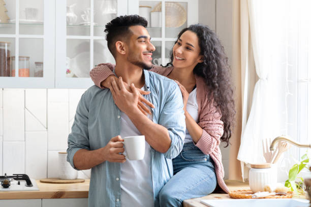 istock Romantic Arab Couple Embracing In Kitchen While Drinking Morning Coffee Together 1322897167