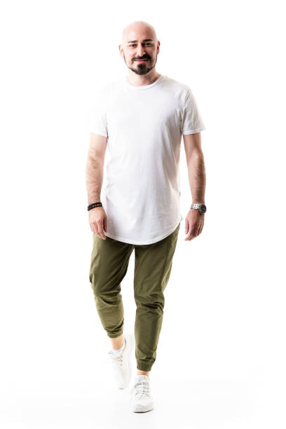 Happy walking bald bearded man in olive green pants and blank white shirt. Happy walking bald bearded man in olive green pants and blank white shirt. Full body length isolated on white background approaching stock pictures, royalty-free photos & images