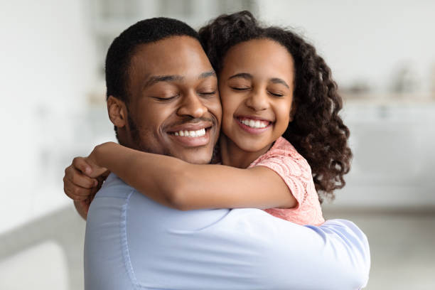istock Ecstatic black father and daughter hugging with closed eyes 1322897489