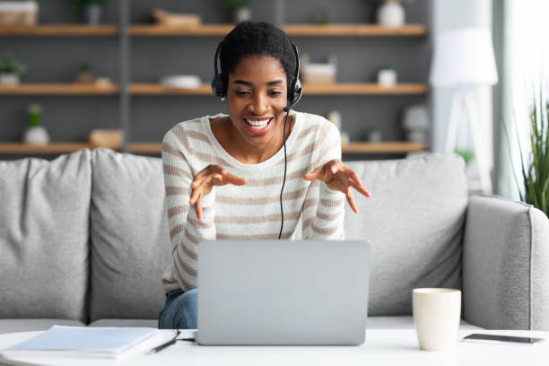 istock Online Conference. Young Black Lady In Headset Having Web Call On Laptop 1322898756