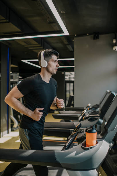 istock male athlete jogging on treadmill in a gym 1322899983