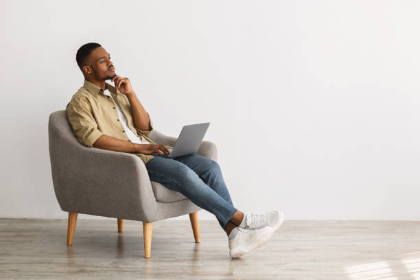 istock African American Freelancer Guy With Laptop Thinking Sitting Indoor 1322900752