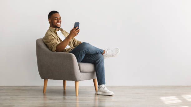 istock Cheerful African American Guy Using Mobile Phone Over Gray Background 1322900767