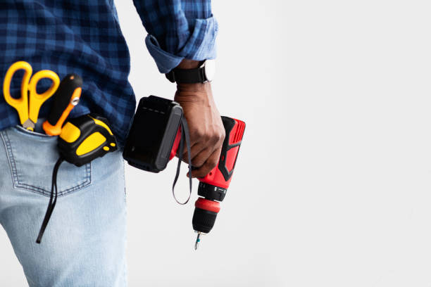 istock Men work concept. Black man holding screwdriver, with tools in pocket, white background with free space, back view 1322900784