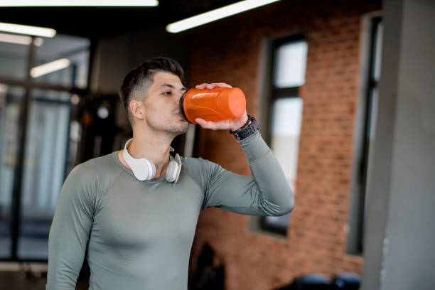 istock Man drinking water after training in gym 1322901127