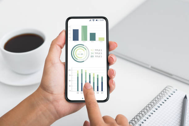 istock Business analyst holding mobile phone with trading app 1322901901