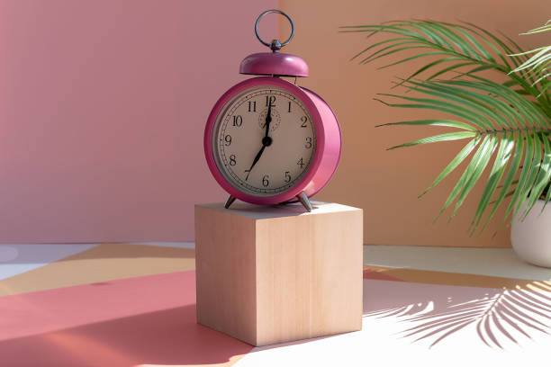 istock pink alarm clock on the podium, sunny morning 1322902189