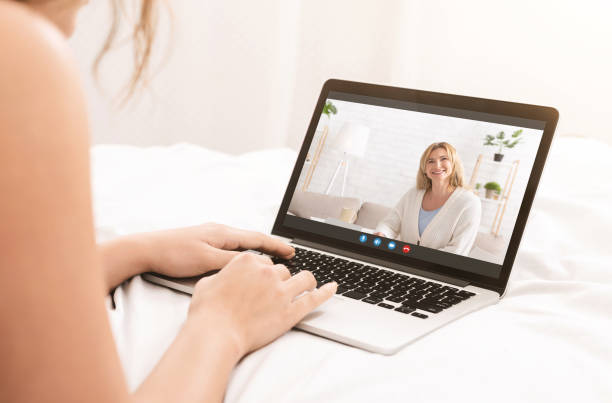 istock Young woman videoconferencing with her mature mother on webcam, using laptop pc to speak to her parent in bed 1322903678