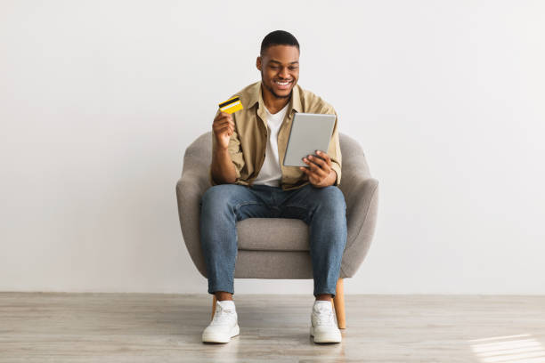 istock Man Using Tablet And Credit Card Shopping Online, Gray Background 1322904687