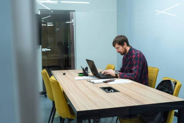 istock Young freelancer working in the office on a laptop at the office desk. Side view 1322906267