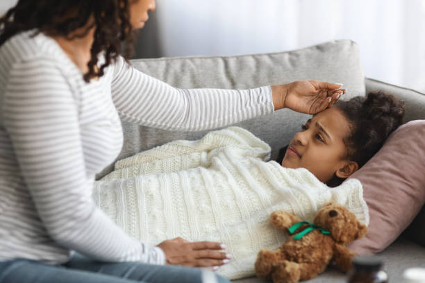 istock Worried mother checking her sick daughter body temperature 1322906371