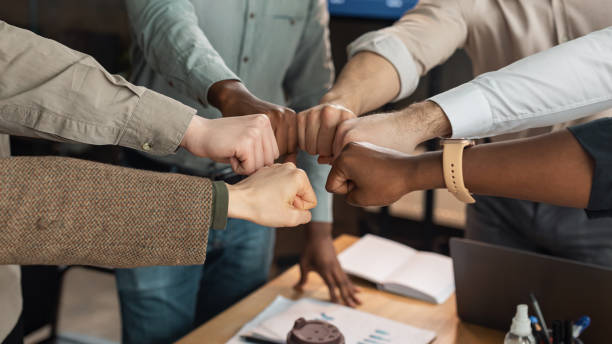 portrait of diverse business people giving fist bump in circle - partnership imagens e fotografias de stock