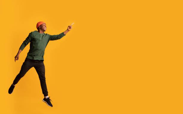 istock Look There. Excited African Guy Jumping And Pointing Aside At Copy Space 1322909523