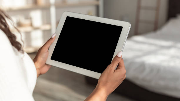 istock African American female holding tablet with blank screen 1322911213