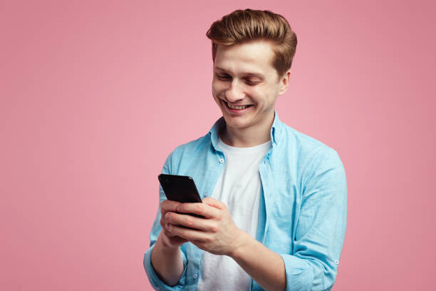 istock Positive smiling man uses modern smartphone for chatting online 1322911441