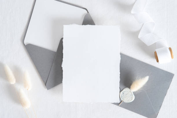 istock Elegant wedding stationery set. Wedding invitation card templates, grey envelopes, silk ribbon, dried flowers on white background. Flat lay, top view, copy space. 1322911604