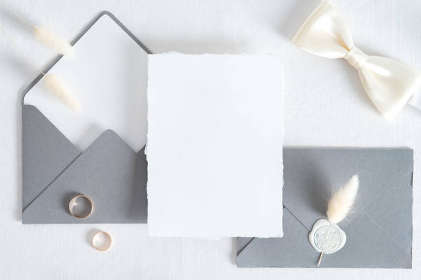 istock Wedding invitation card template. Flatlay blank paper card, grey envelopes, goled rings on white background. Vintage style. Top view. 1322911608