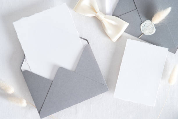 istock Flatlay wedding stationery set on white background. Open envelope with invitation card mockup, dried flowers top view. 1322911614