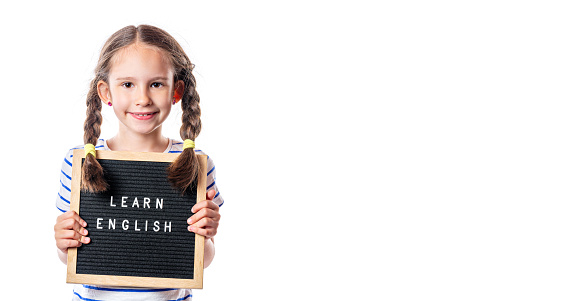 Cute little european girl with letterboard Learn English isolated on white background. English school. Free space for your text.