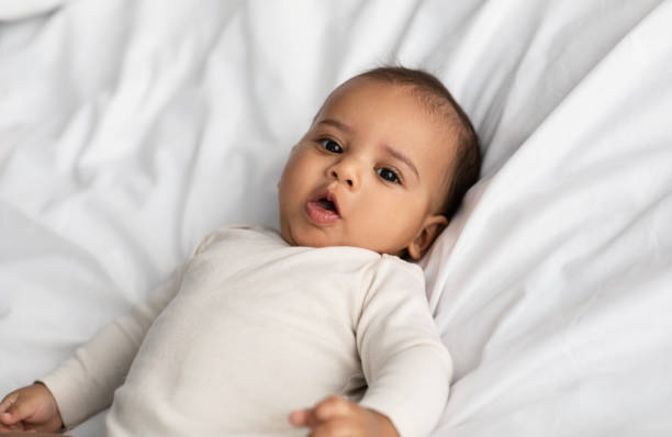 Cute little African American infant lying in bed