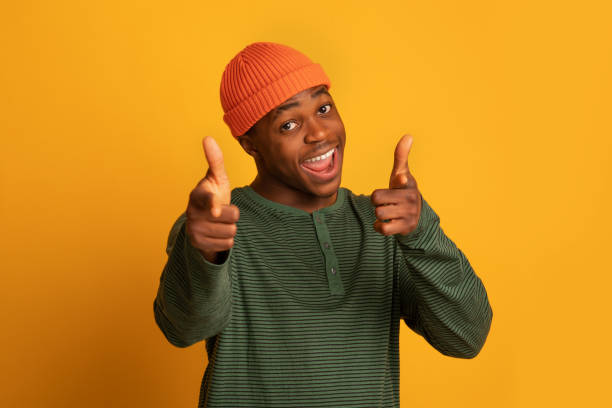 istock Gotcha. Cheerful black hipster guy pointing at camera with two hands 1322913678