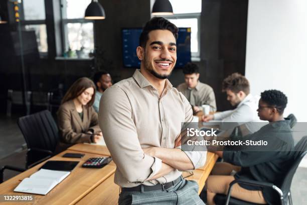 Young Bearded Businessman Sitting On Desk And Posing Stock Photo - Download Image Now