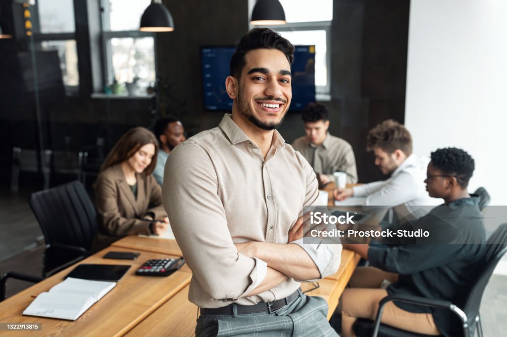 Young bearded businessman sitting on desk and posing - 免版稅商務圖庫照片