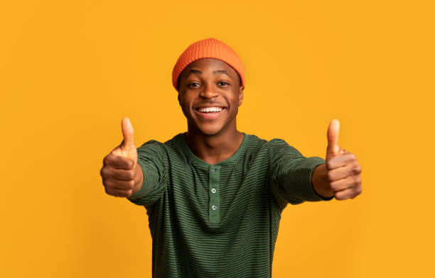 istock I like it. Cheerful black hipster guy showing thumbs up at camera 1322914090