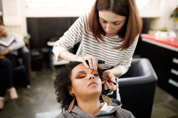 mujer negra siendo hecha con sombra de ojos de colores - makeup artist fotografías e imágenes de stock
